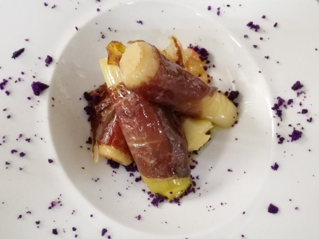 Puerros confitados a baja temperatura envueltos en cecina de León con vinagreta de tomate, aperitivo navideño leonés