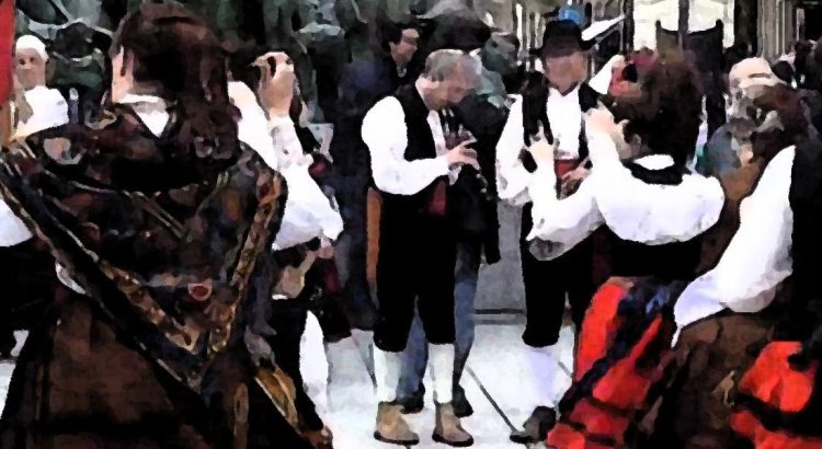 Bailarines interpretando la jota leonesa con trajes típicos, pandereta y dulzaina en un evento de bailes tradicionales de León