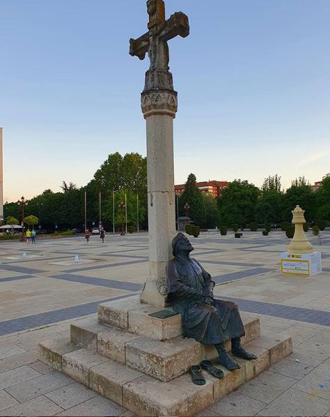 Monumento al Peregrino descansando junto a la cruz de piedra en la plaza de San Marcos de León.