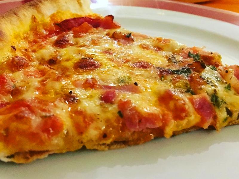 Tapa gratuita de pizza con bacon y queso cabrales de la pizzería La Competencia, un sitio imprescindible de tapas por León.